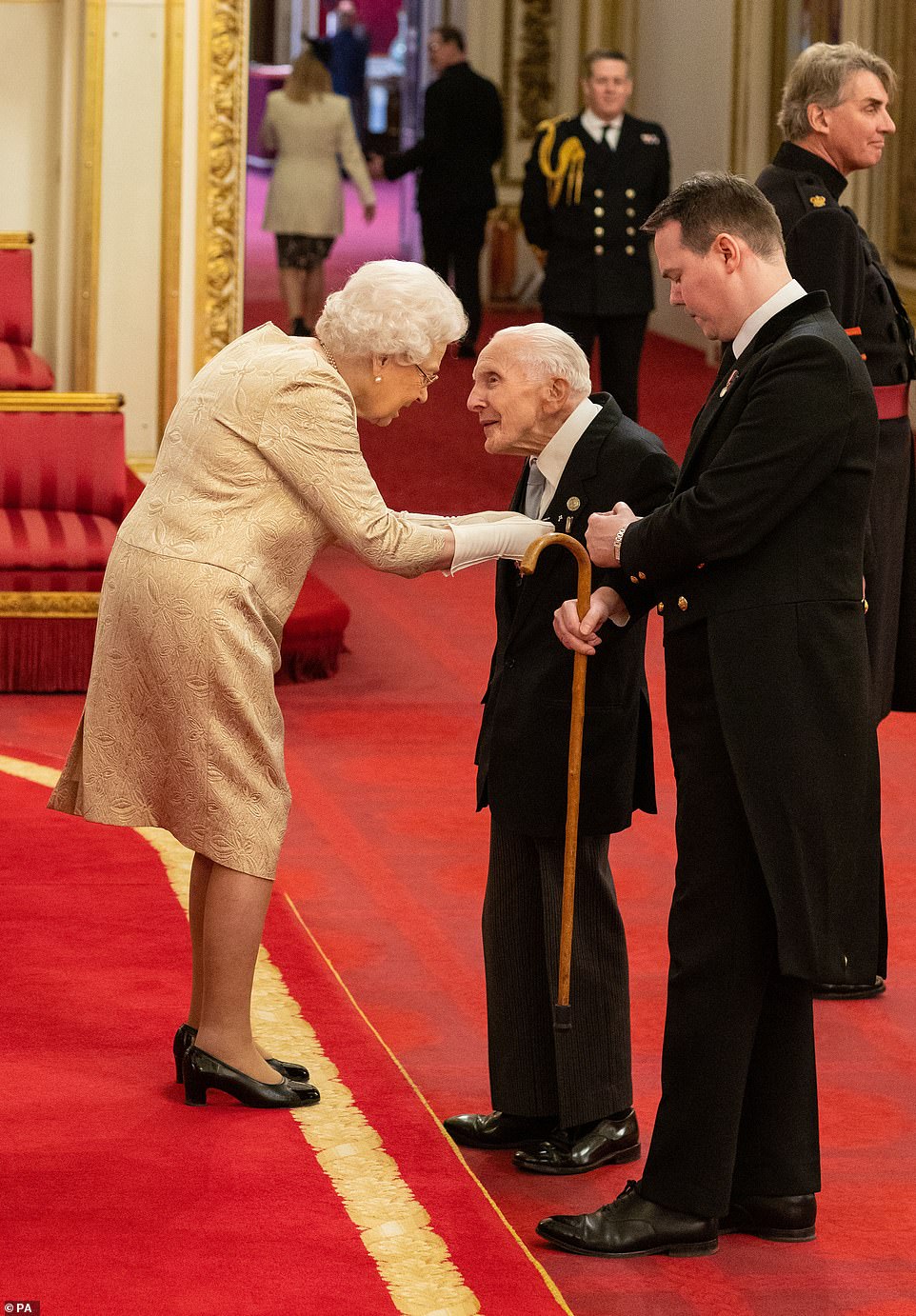 Queen dons gloves at an investiture for first time since 1954 amid coronavirus fear